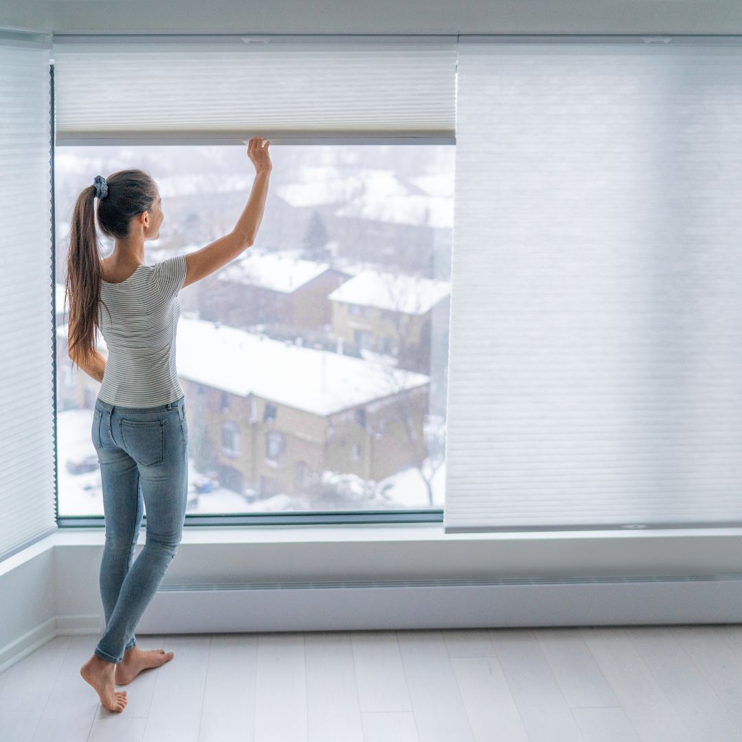 Woman pulling cordless blinds closed